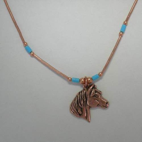 close up of horse head pendant of necklace