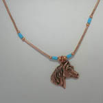 close up of horse head pendant of necklace