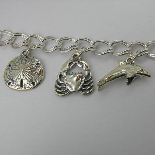 Close up of Sand Dollar and Sea Crab and Dolphin charms on Sea Life bracele