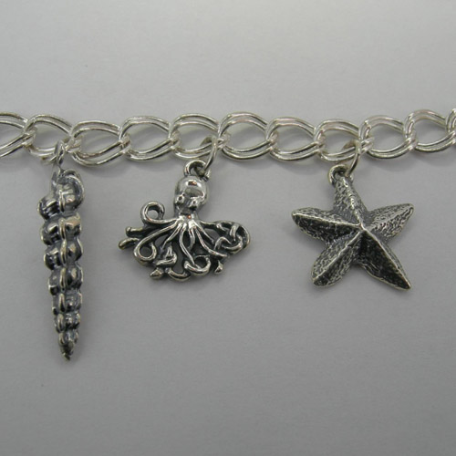 Close up of Conical Shell and Octopus and Sea Star on Nautical Charm Bracel