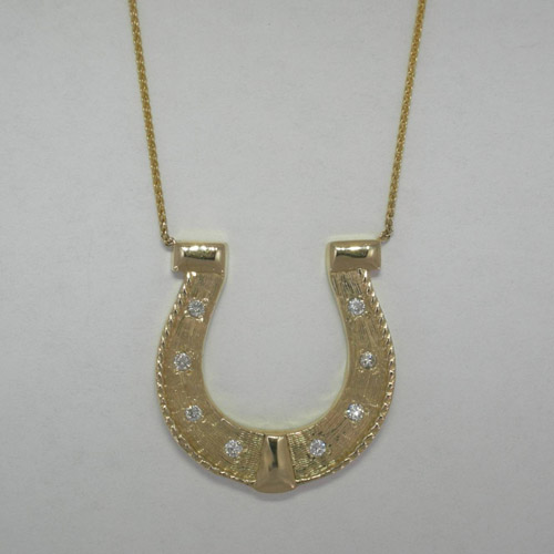 Custom 14 karat yellow gold and diamond horseshoe necklace close up