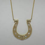 Custom 14 karat yellow gold and diamond horseshoe necklace close up