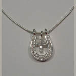 close up of C Z cross and horseshoe necklace